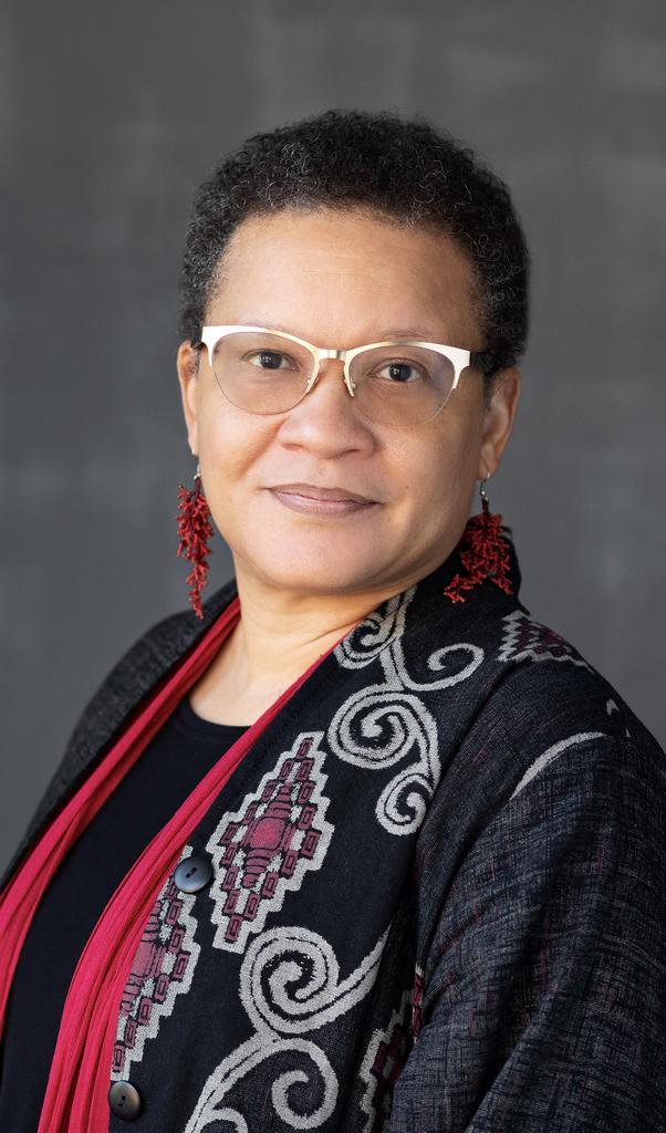 Kimberly Jackson Davidson is wearing a black and red outfit in front of a black background.