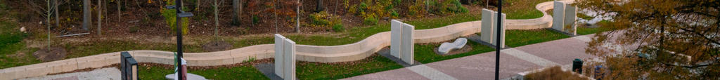 Wilkins Plaza near Fenwick Library. The concrete ridge between them forms a wavy line, next to which are benches and surfaces for students to advertize activities.